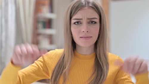 Woman Giving Thumbs Down Gesture in Home