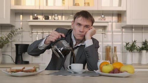 Adult Man Pours Coffee in a Bright Kitchen