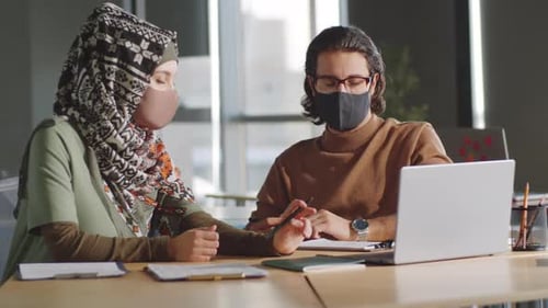 Muslim Colleagues in Masks Discussing Business in Office