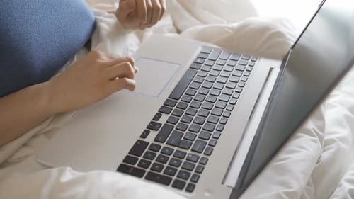Woman Typing on Laptop While in Bed