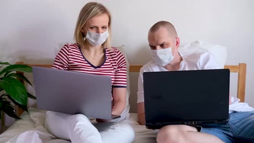 Young Family Works Remotely From Home on Bed at the Computer