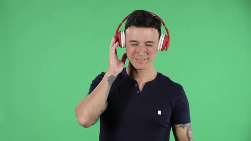 Man Listening Music On Headphones On Green Screen