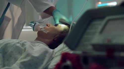 Doctor Checking Patient Oxygen Mask with Flashlight Test in Intensive Care Unit