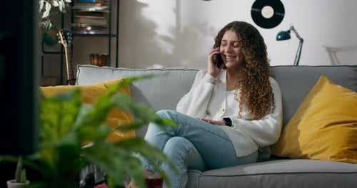 Woman with Curly Hair Talking on Phone Indoors