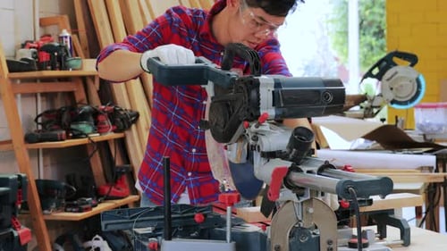 Woodworker Using Saw to Cut Wood in Workshop