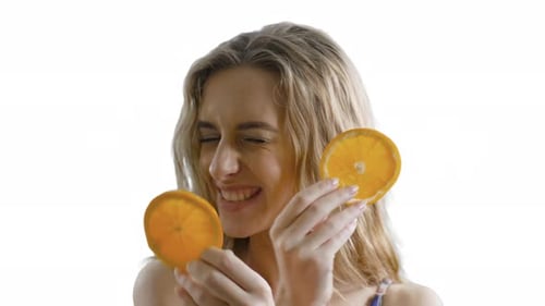 Smiling Woman Posing with Orange Slices on White