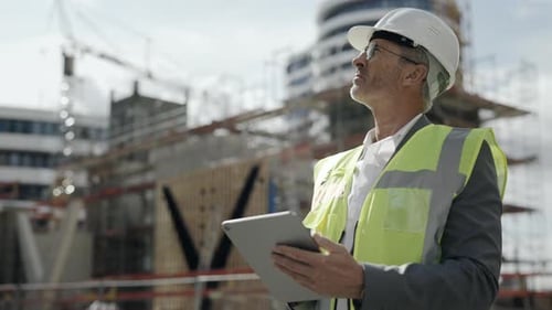 Architekt steht auf der Baustelle und benutzt Tablet