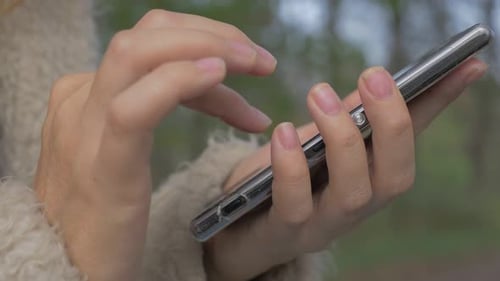 Hands Using Silver Mobile Phone Technology Outdoors