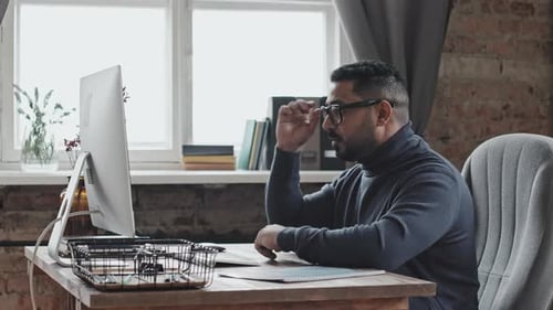Tired Businessman Rubbing Eyes after Video Conference