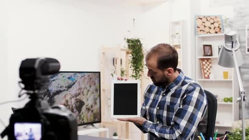 Influencer famoso hablando y revisando una tableta