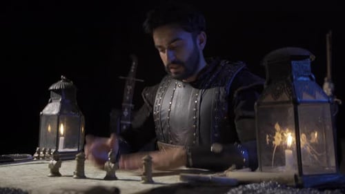 Man Moves Chess Pieces by Lantern Light