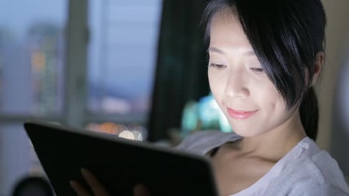 Woman using tablet computer at home