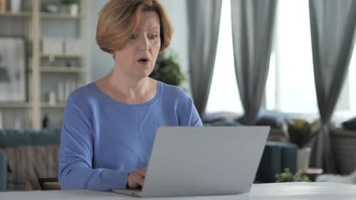 Shocked Woman Using Laptop At Home