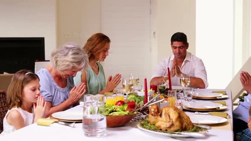 Família extensa pedindo graça antes da ceia de Natal