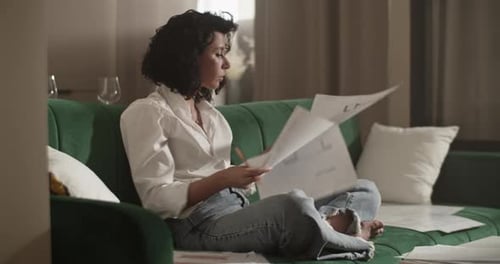 Barefoot Architect Working with Drafts on Sofa