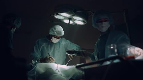 Doctors Team Performing Surgical Operation in Dark Hospital Operating Room