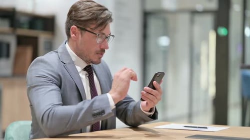 Businessman Using Smartphone in Office