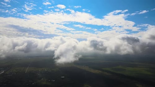 Aerial View From Airplane Window at High Altitude of Earth Covered with White Puffy Cumulus Clouds