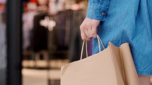 Woman's hand holding full shopping bags