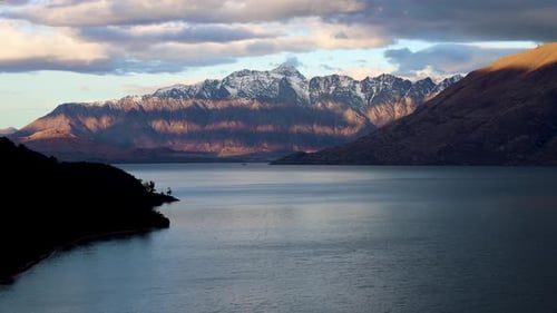 Beautiful time lapse of moody cloudy Sunset of the Remarkables mountain range. At Bobs Cove of Lake