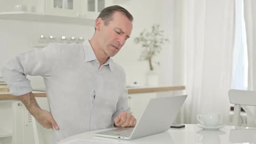 Man Working at Laptop Develops Back Pain