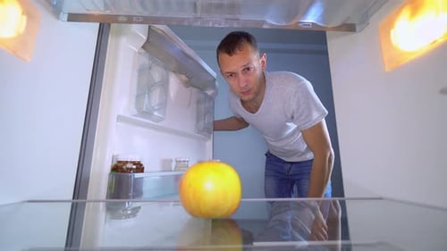 Thoughtful Man Opens Near Empty Refrigerator
