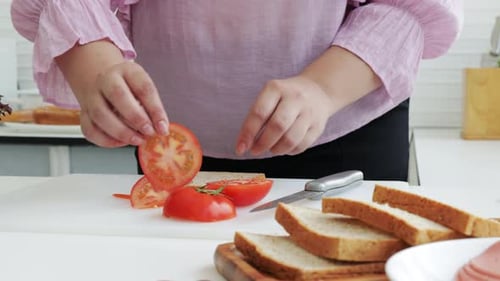 Overweight woman make a sandwich salads for dieting weight loss. Close-up shot