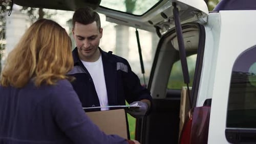 Deliveryman Giving Package To Woman Outside Her Home