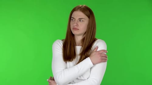 Woman Shivering and Praying Against Green Screen