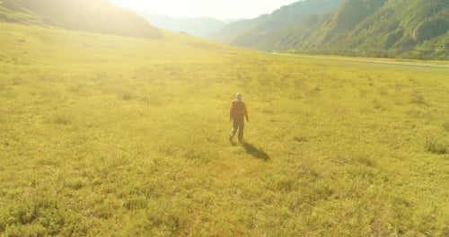 Flight Over Backpack Hiking Tourist Walking Across Green Mountain Field