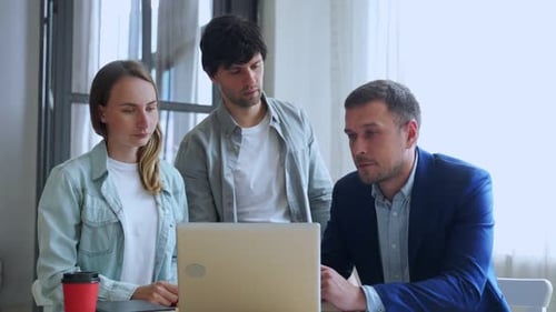 Young Business People Working with Laptop and Talking of They New Project Together in the Office.