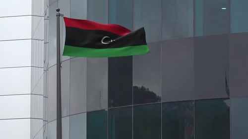 Realistic Flag of Libya Waving in Front of Modern Building