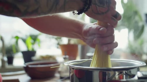 Person Cooking Spaghetti in Bright Indoor Kitchen