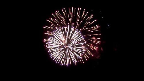 Feux d'artifice lumineux pendant les vacances. Dans le ciel nocturne brille une boule de feu pourpre. Un intéressant