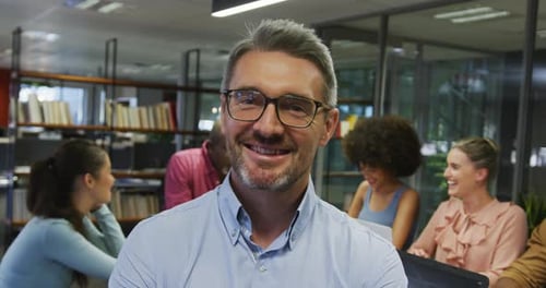 Smiling Man with Diverse Colleagues in Urban Office