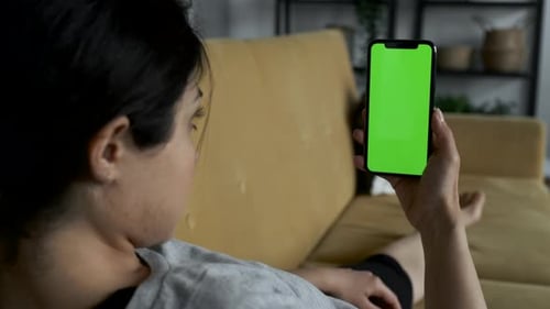 A Woman's Hand Holds A Smartphone With A Green Screen For Chromakey. Blank digital smartphone