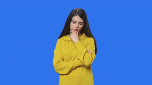 Young Woman Thinking in Front of Blue Screen