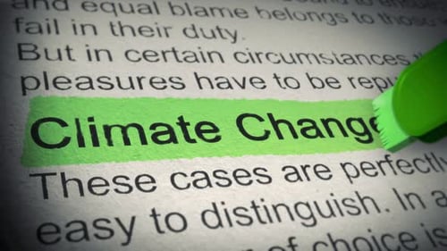 Climate Change. Highlighter pen marks word in an open book. Closeup. Thumbing pages and promoting te