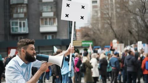 Man with Megaphone Leads Protest in City Street