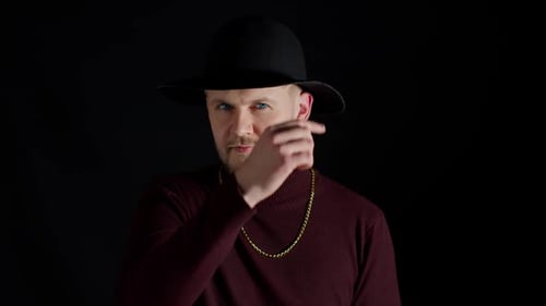 Facial Expression of Handsome Man in Stylish Hat Looking at Camera and Smiling on Black Background