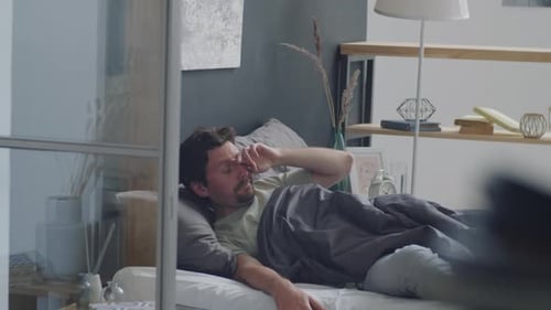 Man Wakes Up and Uses Phone in Bed