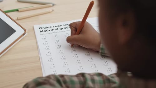 Unrecognizable Kid Solving Addition Problems