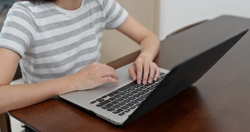 Utilisation d'un ordinateur par une femme à la maison