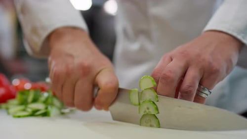 Hands of Chef Cutting Fresh Cucumber