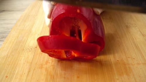 Cutting Red Bell Pepper on Wooden Board