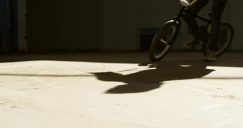 BMX rider in an empty warehouse
