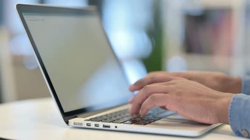 Close Up of Hands of African Man Typing on Laptop Keypad