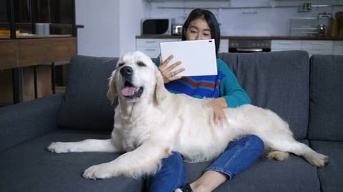 Woman Relaxes with Her Dog and Tablet