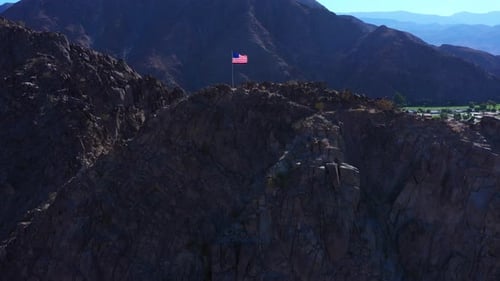 American Flag Waving Proudly on Rocky Mountain Top