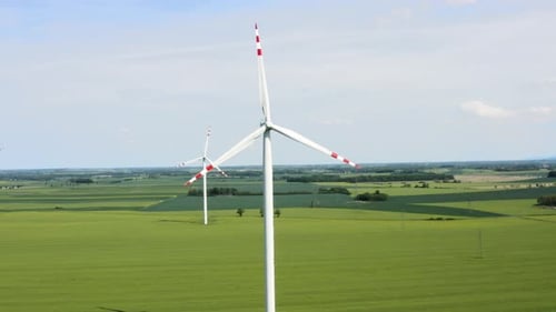 Wind Turbines Spinning in Rural Green Field